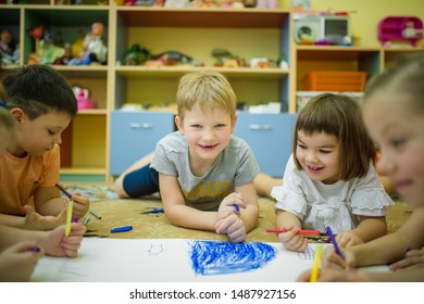 07,02,2019 Russia, Moscow several children draw on a white sheet with felt-tip pens lying on the floor in a kindergarten - Shutterstock ID 1487927156