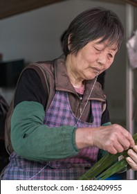 07.05.2019 Shanghai Xinchang Ancient Town, China. An Elderly
Woman Prepares To Make Zongzi With Bamboo Leaves.