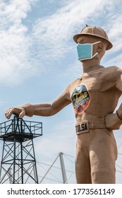 07_09_2020 Tulsa, USA_Iconic Golden Driller - Giant Statue Of Oilfield Worker  Near Route 66 In Oklahoma Wearing Hard Hat And Facial Mask With Hand On Oil Derrick During Pandemic