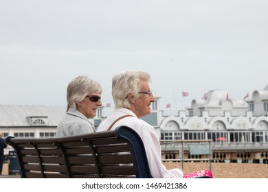 08/03/2019 Portsmouth, Hampshire, UK Two Elderly Ladies Or Women Sat On A Bench Talking At The English Seaside