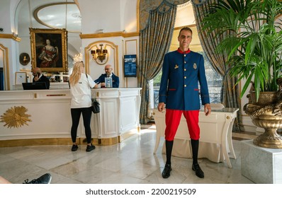 08-31-2022 Nice, Frsnce.  Interior   And Porter(doorman) Inside Hotel Negresco In Nice  And Blondie - Woman - Client Near Reception Desk