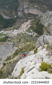 09-04-2022, Orpierre, Hautes Alps-Drome, France: Rock climber on the 'Rocher de Quiquillon' a part of the climbing area of Orpierre, France with the village below