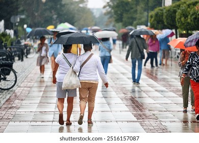 09.10.2024 mielno, poland, People under umbrellas during rain and wind on the promenade. - Powered by Shutterstock