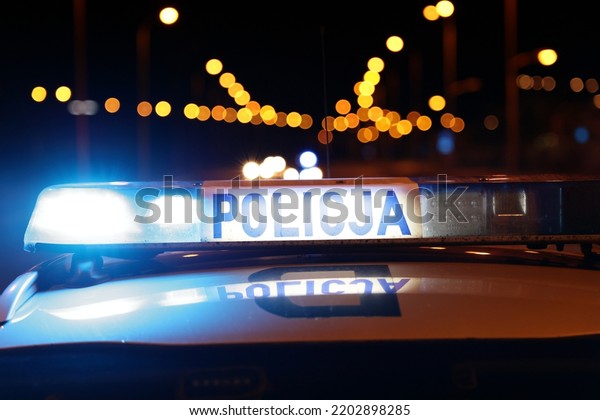 09.23.2021 wroclaw, poland, Night police emergency\
intervention - Blue flashing light on the roof of a Polish police\
car at night.