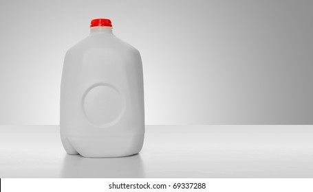 1 Gallon of Milk in a milk carton on a shiny table with white background.