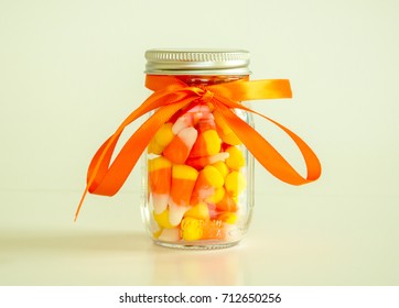 1 Mason Jar Filled With Candy Corn Tied With Orange Ribbon Isolated On A Solid Background