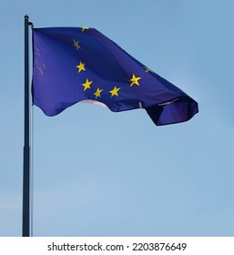 1 One, Alone Flag Of European Union. EU. Wave On Wind. Blue Sky Background. Europa. European Union Flag Blowing On Flag Pole In Wind In Front Clear Blue Sky.