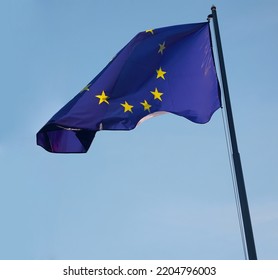 1 One, Alone Flag Of European Union. EU. Wave On Wind. Blue Sky Background. Europa. European Union Flag Blowing On Flag Pole In Wind In Front Clear Blue Sky.