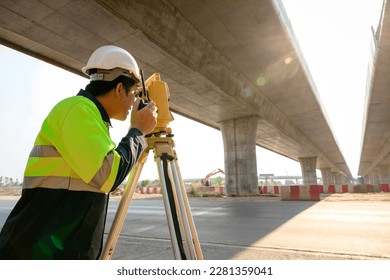 1 Surveyor Engineer using theodolite in the construction motorway bridge Engineer working and theodolite marking concrete bridge piles at construction site