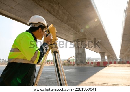 1 Surveyor Engineer using a theodolite in the construction of a motorway bridge Engineer working with theodolite marking concrete bridge piles at construction site Foto stock © 