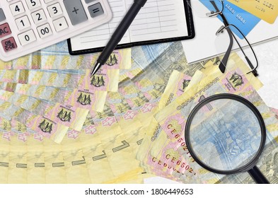 1 facturas de jrivnia ucraniana y calculadora con gafas y bolígrafo. Concepto de temporada de pago de impuestos o soluciones de inversión. Buscar un trabajo con un salario alto