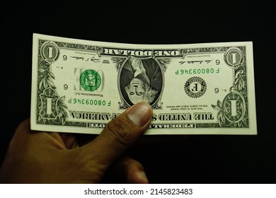 1 USD, US dollar money, was held by businessman isolated on black background