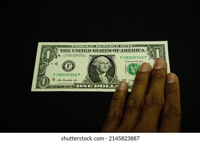 1 USD, US dollar money, was held by businessman isolated on black background