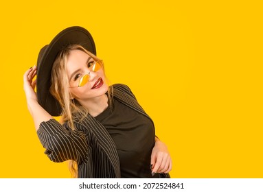  1 Young White Woman In A Black Jacket And Hat On A Yellow Background