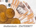 10 British pounds bills and golden bitcoins. Cryptocurrency investment concept. Crypto mining or trading transactions