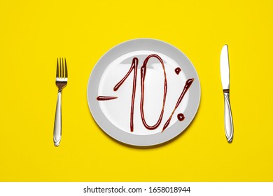 10% discount on food. Plate with the inscription ketchup and fork with knife on white table.