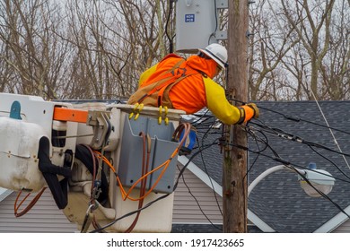 10 FEBRUARY NYC NY USA: Electrician repair system of electric wire on wooden pylon after snowfall wet snow to electric wires.