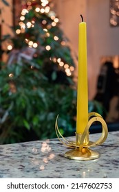 A 10 inch taper candlestick is displayed with a Christmas tree in the background.
