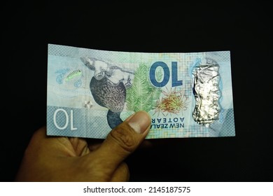 10 NZD, Left Hand Businessman Holding Ten New Zealand Dollar