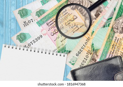 10 sri-lankische Rupien Rechnungen und Lupe Glas mit schwarzer Handtasche und Notizblock. Konzept der Geldfälschung. Suchen Sie nach Unterschieden in den Details der Geldrechnungen, um Fälschungen aufzudecken
