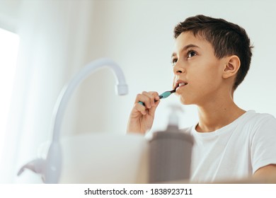 10 Year Old Boy Brushing His Teeth In The Bathroom