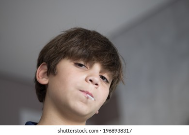 10 Year Old Boy Sucking Lollipop. Low Angle.