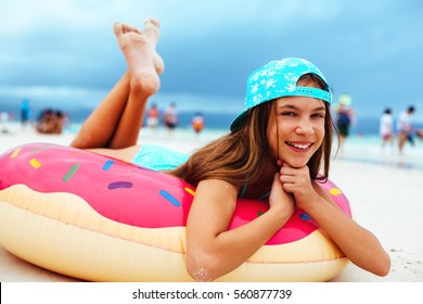 10 years old girl relaxing on lilo on the beach.