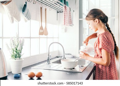 10 Years Old Kid Girl Cooking In The Kitchen, Casual Lifestyle Photo Series. Child Making Breakfast Alone. Cozy Homely Scene.