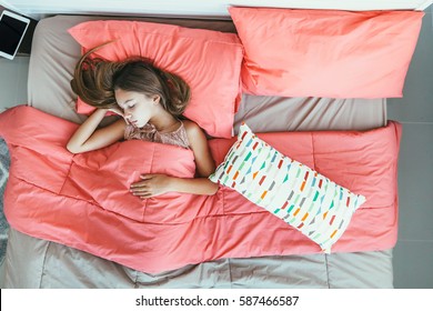 10 Years Old Pre Teen Kid Girl Sleeping In The Bed With Pink Bedding, Top View