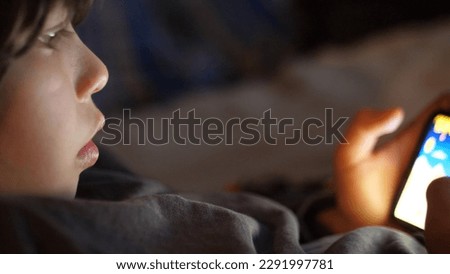 10 yearsold boy using a mobile phone at home