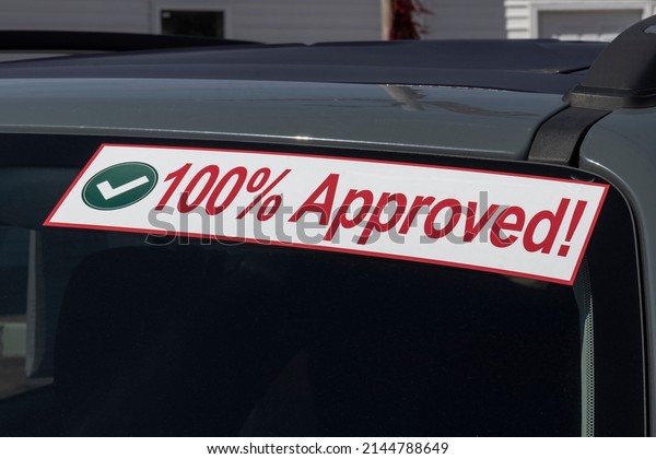 100% Approved sign at a\
Buy Here Pay Here used car lot. Many buy here pay here car\
dealerships do not require good credit but may track your car if\
you miss payments.