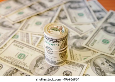 100 dollar bills with the wedding ring - Shutterstock ID 496966984