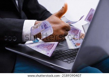 100 Malaysian ringgit notes coming out of laptop with Business man giving thumbs up, Financial concept. Make money on the Internet, working with a laptop