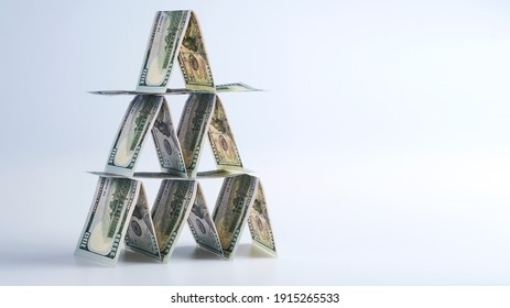 100 us dollar bills lined up in house of cards, money banner concept, financial pyramid, ponzi scheme, affaire, hustle, crook business - Shutterstock ID 1915265533