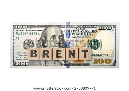 100 US dollar note on a USA flag with wooden cubes and word BRENT. USA trade, duty, customs and tariffs war. Economic inflation, deflation or stagflation 