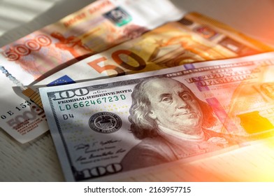 100 US Dollars Banknote Next To 50 Euros And 5000 Russian Rubles. World Currencies. Euro Trading With Dollar And Russian Ruble.