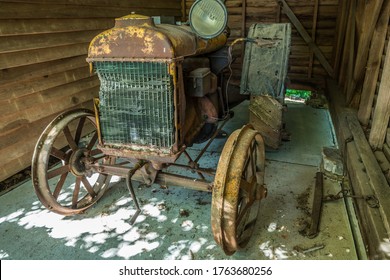 A 100 Year Old Antique Tractor With Crank Start Crumbling And Rusting Away In A Shed Obsolete Farm Equipment