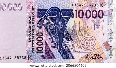 10000 CFA franc bank note. CFA franc is used in 14 African countries. Stylised sawfish which is a reproduction of the bronze figurine which was formerly used to weigh the gold powder among Akan people