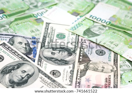 10000 South Korea won and one hundred US Dollar bills on table for money background in concepts of international relation, foreign money exchange, business and financial.