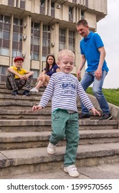 10.05.2019, Tula, Russia. A Little Boy Wearing Stripped Shirt Running Up And Down By Stairs. Kid Having Fun.