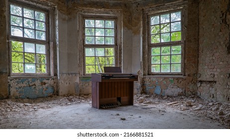 10.05.2022 - Oranienburg, Germany:  Old dusty piano synthesizer in a room with destroyed walls. Abandoned German-Soviet lung hospital. Ruined tuberculosis-Sanatorium "Heilstätte Grabowsee"
