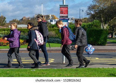 10/09/2019 Portsmouth, Hampshire, UK A Group Of British School Children Walking Past A Bus Stop