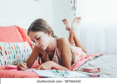 10-12 Years Old Pre Teen Girl Writing Diary In Pink Bedroom