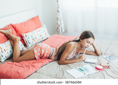 10-12 Years Old Pre Teen Girl Doing School Homework In Pink Bedroom