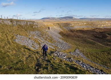 10.12.2021 Crummack, Austwick, Craven, North Yorkshire, UK. Female hill walker at Sulber Gate in the Yorkshire Dales with Pen-y-ghent in the background