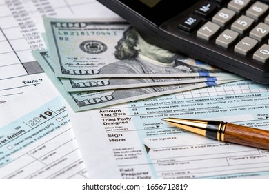 1040 Income Tax Return Form 2019 With Calculator, Money And Pen. Concept Of Filing Taxes, Payment, Refund, And April 15, 2020 Tax Deadline