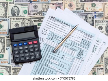 1040 tax form with calculator on the dollars background.