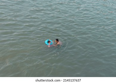 10-APRIL-2019 - Songkran Day, people come to have enjoying at the Ping River. Kamphaeng Phet Province, Thailand. Father and son playing in the water together