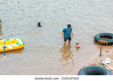 10-APRIL-2019 - Songkran Day, people come to have enjoying at the Ping River. Kamphaeng Phet Province, Thailand. Father and daughter playing in the water together