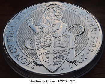 10oz Queens Beast lion solid silver coin at an angle over a dark background